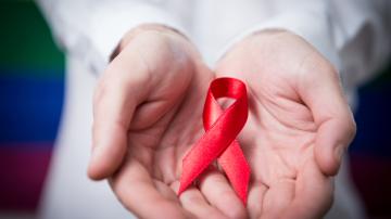 Man holding red aids ribbon