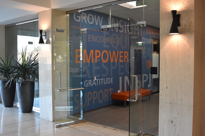 Open glass entrance doors and wall with inspirational words