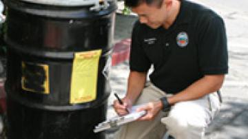 County Employee Beside Barrel