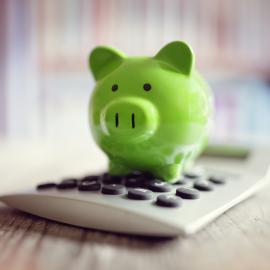 Green piggy bank on a calculator